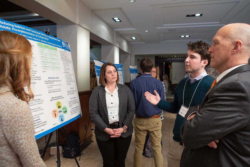 Elizabeth Hill (left), Autumn Baldwin (middle), and Thomas Finn (right) presenting their poster.
